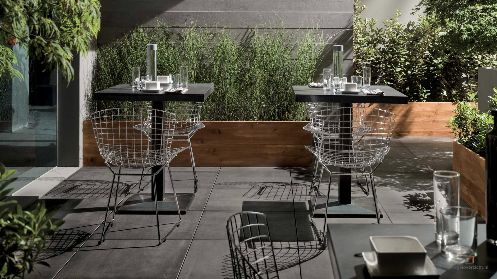 Terras met betonlook tegels, bistrostoelen en bamboe